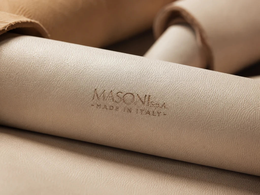 Beige leather rolls with a Masoni Made in Italy stamp, showing the surface texture.