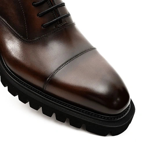 Dark brown cap-toe leather shoe with a chunky black lug sole